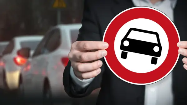 Zabrane prawo jazdy na 3 lata co dalej? Znak zakazu wjazdu samochodów i stojące w korku auta symbolizują trudną sytuację kierowcy.