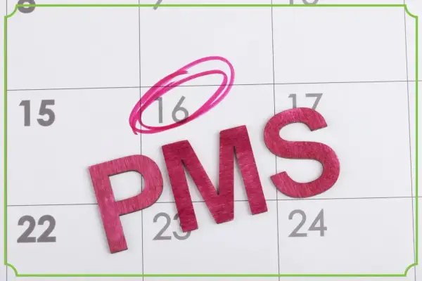 Litery PMS na kalendarzu. Dzień 16 zaznaczony kółkiem, sugerując fałszywe objawy ciąży.