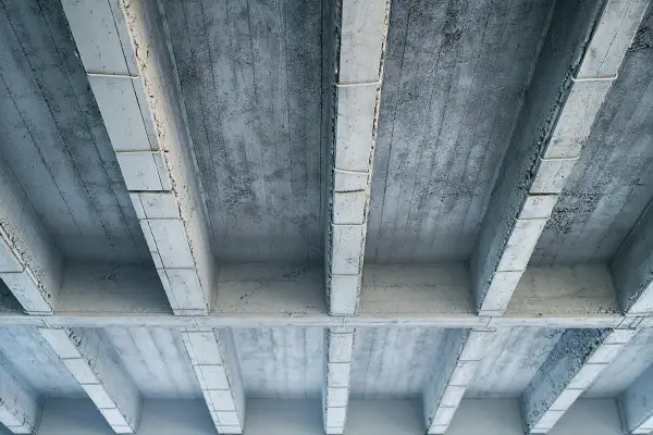 Betonowy strop z widocznymi belkami i płytami. Szukając, jaki strop najtańszy, warto rozważyć takie proste konstrukcje.