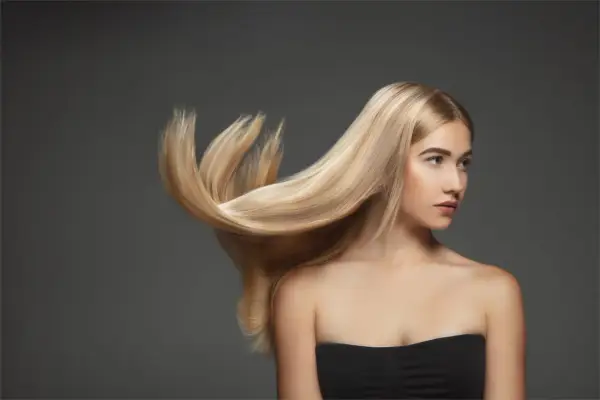 Blond włosy modelki falują, ukazując ich zdrową budowę.