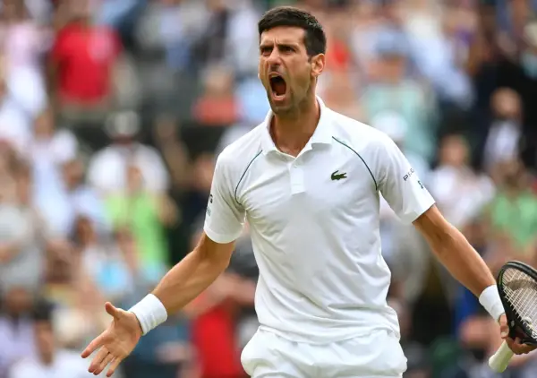 Emocjonalny tenisista Djokovic krzyczy z kortu, świętując zwycięstwo.