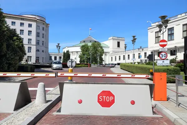 Przed Sejmem RP, gdzie dyskutuje się, ile wynosi dieta poselska, szlaban i znak STOP.