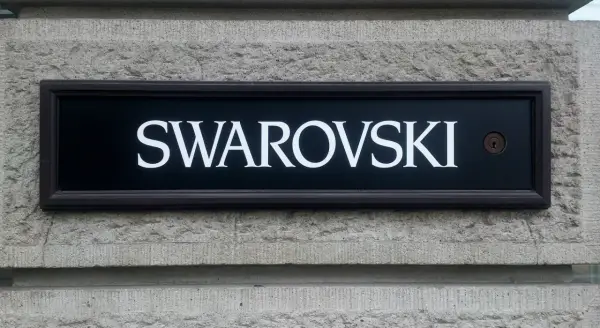 Tablica z napisem SWAROVSKI, symbolizująca luksus i precyzję, przypomina o austriackich korzeniach marki.