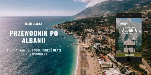 Przewodnik po Albanii, który sprawi, że Twoja podróż będzie niezapomniana. Widok na wybrzeże i góry, z telefonem prezentującym okładkę książki o Albanii.