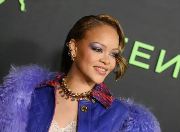 Rihanna w fioletowym futrze i biżuterii, z makijażem oczu.