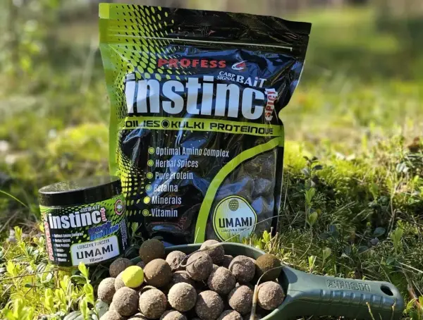 Profesjonalne kulki na karpia Instinct Umami w słoiczku i opakowaniu. Na łopatce widoczne są gotowe do użycia kulki proteinowe.