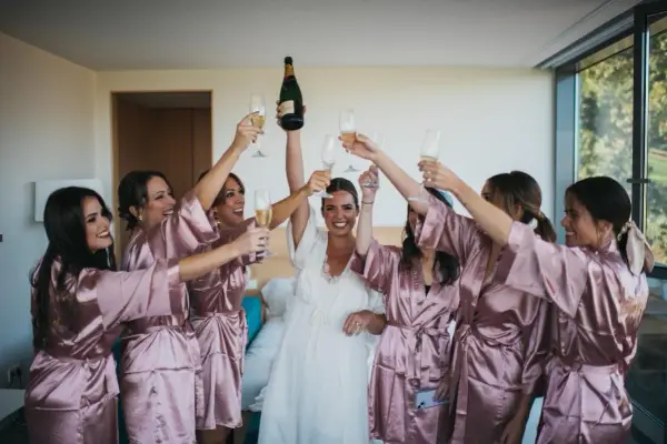 Novia y damas de honor brindan con champán, ¡ideas para despedidas llenas de alegría y celebración!