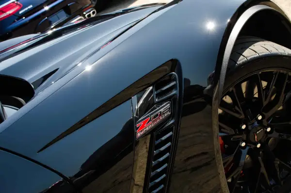 Svart Corvette med "Z06 SUPERCHARGED"-emblem. Lacken är så blank att den nästan ser ut som en keramisk detaljer.