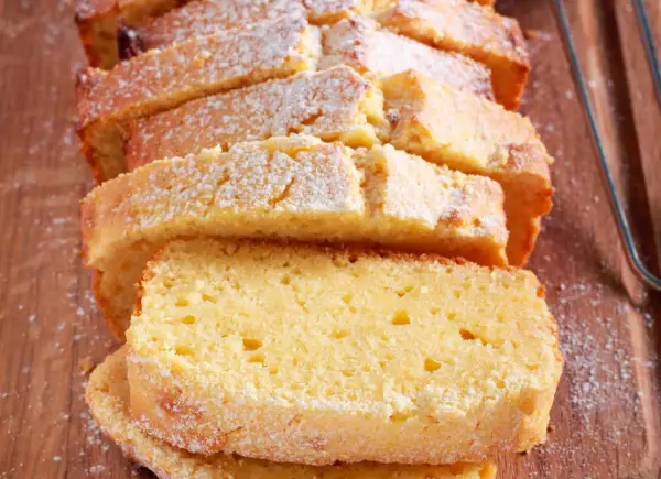 Puszyste ciasto cytrynowe, pokrojone w plastry i posypane cukrem pudrem. Idealny przepis na ciasto na niedzielne popołudnie.