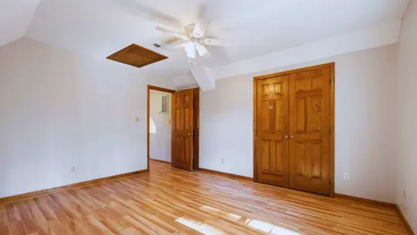 Habitación con suelo de madera clara y puertas de madera oscura, creando un contraste cálido.
