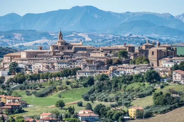 Panoramica di Corinaldo, borgo medievale nelle Marche, con le sue case in pietra e le colline verdi circostanti.