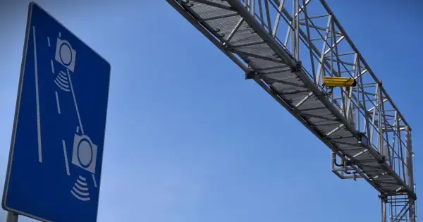 Niebieski znak informuje o odcinkowym pomiarze prędkości S7. Nad drogą widać konstrukcję z żółtą kamerą.