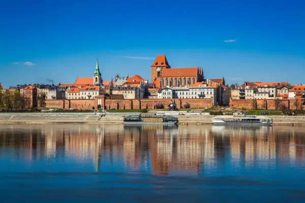 Widok na zabytkowe centrum Torunia z Wisłą w tle. Zobacz, co warto zobaczyć w Toruniu: katedrę, ratusz i średniowieczne mury.