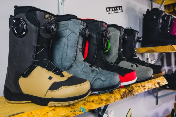 Rząd męskich butów snowboardowych w różnych kolorach, od beżowego po czarny, gotowych na zimowe szaleństwo.