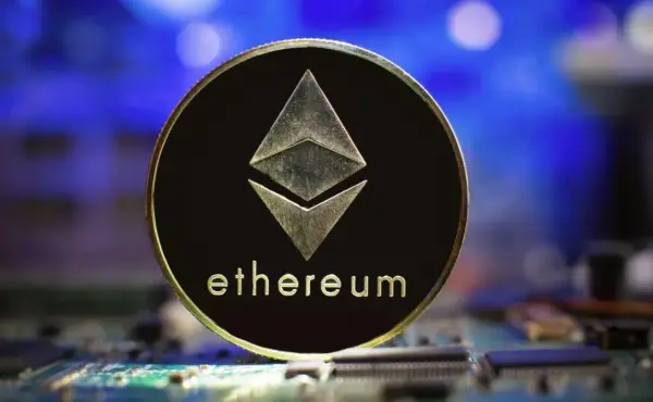 Złoty token Ethereum z symbolem sieci i napisem "ethereum" na tle niebieskiego światła i obwodów drukowanych. To symbol technologii ERC-20.