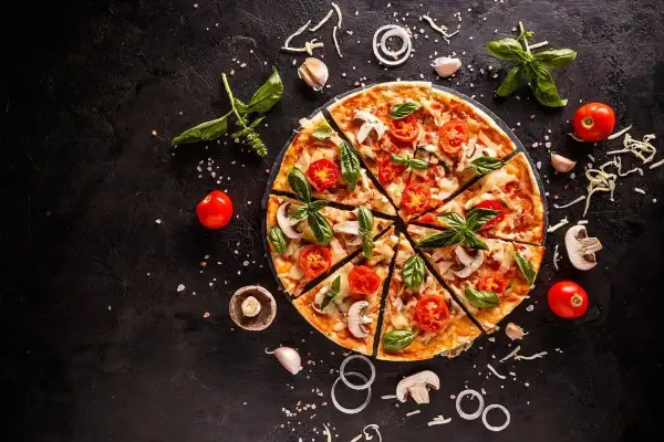 Apetyczna pizza z pomidorami i bazylią. Czy pizza jest zdrowa? Zależy od składników!