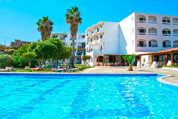 Basen i białe budynki hotelowe z palmami. Wiele osób odpoczywa na leżakach. Ocean Heights View Hotel opinie - idealne miejsce na wakacje.