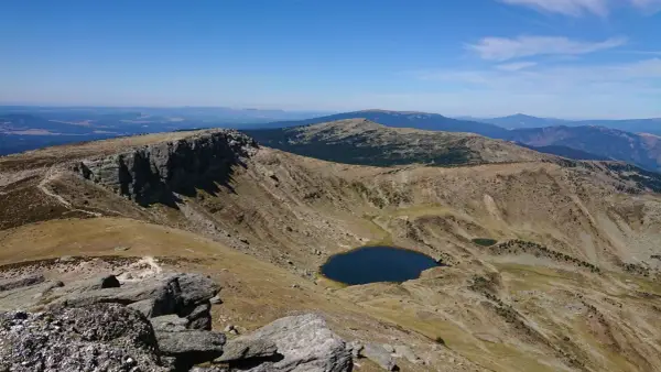Paisaje montañoso con un lago azul en un valle, ideal para senderismo Soria.