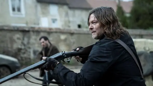 Daryl Dixon z sezonu 3, z blizną na twarzy, celuje z dwururki. W tle inny mężczyzna.