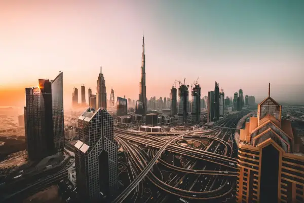 Zachód słońca nad Dubajem, z drapaczami chmur i skomplikowanymi węzłami drogowymi. Czy w Dubaju jest bezpiecznie? Tak, to nowoczesne miasto oferuje spokój.