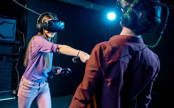 Para grająca w gry na Google VR, zanurzona w wirtualnej rzeczywistości, z kontrolerami w dłoniach.