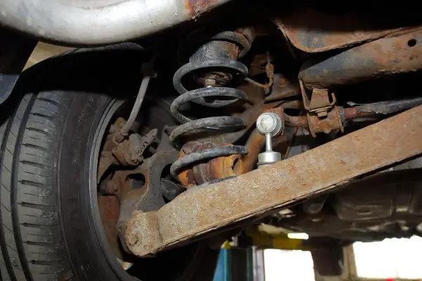 Rdza i zużycie elementów zawieszenia, sprężyna i amortyzator mogą powodować skrzypienie podczas jazdy po nierównościach.