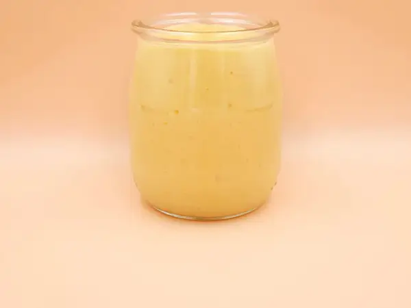 Gęsty, kremowy mango lassi w szklanym słoiku, gotowy do orzeźwiającego łyku.
