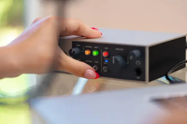 Dłoń z czerwonym lakierem na paznokciach dotyka panelu urządzenia, pokazując jak podłączyć mio smartbox iii.