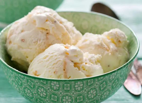 Kremowe lody z mascarpone w zielonej miseczce, idealne na upalny dzień.