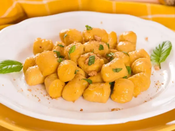 Kopytka z dyni wg Gesslerowej, delikatne i aromatyczne, posypane świeżą bazylią i okruszkami.