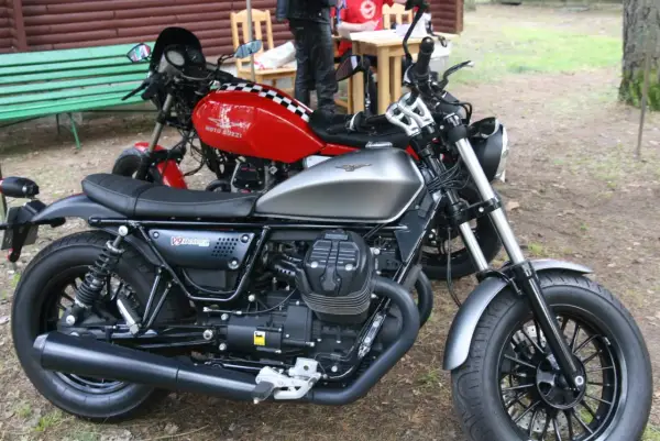 Dwa motocykle Moto Guzzi, jeden srebrny, drugi czerwony z szachownicą. Może to przypomnienie o opłacie skarbowej za motocykl z zagranicy.