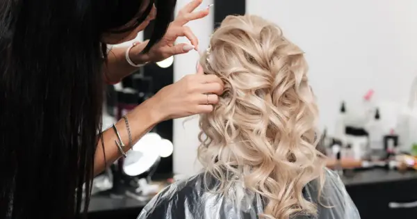 Fryzjer po hiszpańsku, czyli "peluquero", tworzy piękną fryzurę ślubną z blond loków.