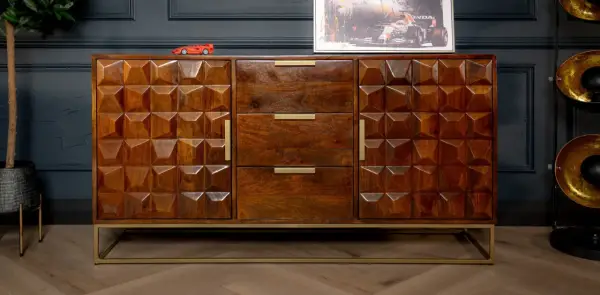 A geometric carved mango wood finish sideboard with brass handles and a gold metal base.