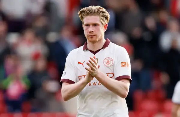 Kevin De Bruyne, w białej koszulce Manchesteru City, klaszcze w dłonie. Jego obecne drużyny to Manchester City.