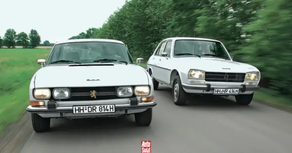 Dwa białe Peugeot 504 jadące obok siebie po wiejskiej drodze.