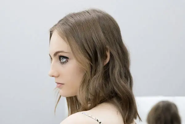 Chica con media melena escalada y maquillaje dramático en los ojos.
