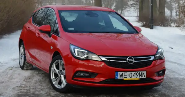 Czerwona Astra K 1.6 CDTI na tle zimowego krajobrazu.