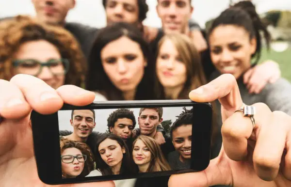 Grupa przyjaciół robi selfie. To pokolenie z od kiedy? Zawsze razem, uśmiechnięci i gotowi na nowe przygody.