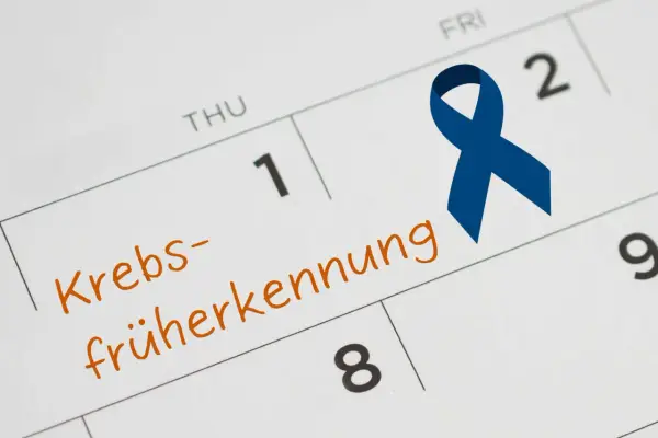 Kalenderblatt mit "Krebsfrüherkennung" und einer blauen Schleife. Wichtig für die Krebsvorsorge Mann.