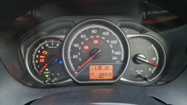 Kontrolka silnika świeci się na desce rozdzielczej Toyoty, wskazując błąd DTC P1604. Oprócz tego widoczne są kontrolki oleju, akumulatora i temperatury.