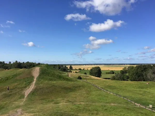 Gröna kullar och en stig leder till en fantastisk utsikt över fält och skog. Upplev Uppsala från ovan!