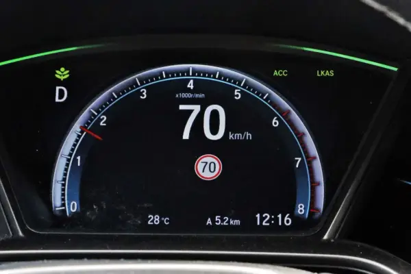 Cyfrowy prędkościomierz samochodu pokazuje 70 km/h, obok wskaźnik temperatury i zegar.
