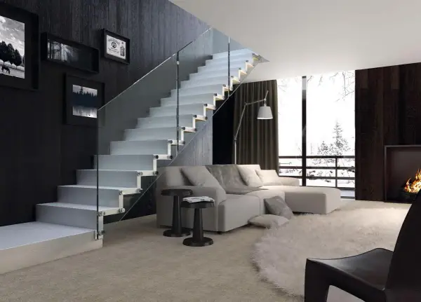 Escalera moderna de cristal con peldaños blancos y barandilla de vidrio en un salón luminoso.