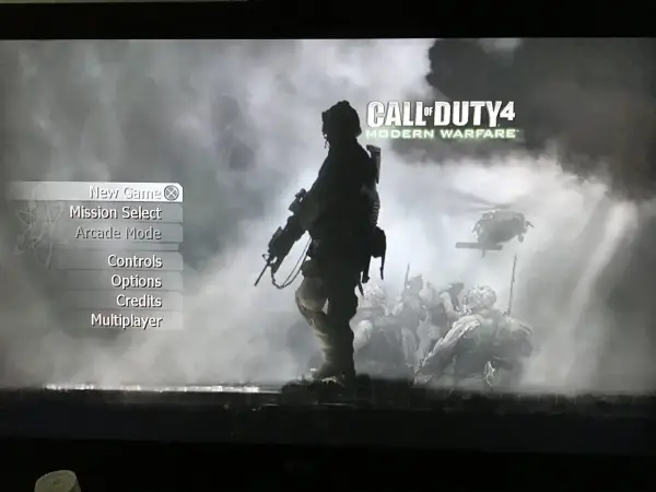 Menu gry Call of Duty 4: Modern Warfare. W tle żołnierze i helikopter.