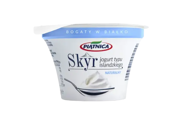 Opakowanie jogurtu typu islandzkiego Skyr Piątnica Naturalny z łyżką pełną jogurtu.