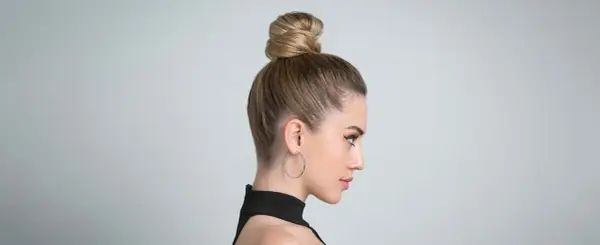 Moño alto y pulido, ideal para peinados para verano.