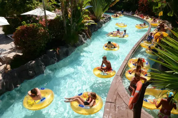 Un día perfecto de diversión en Tenerife con niños, flotando en un río artificial rodeado de vegetación exuberante.
