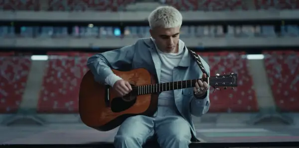Mata gra na gitarze w pustym stadionie, zapowiadając swój nowy album.