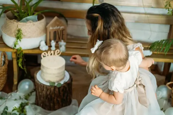 Mama z córką przy torcie na roczek. Piękny tort i dekoracje, idealne na prezent, co kladzie sie dziecku do wyboru na roczek.