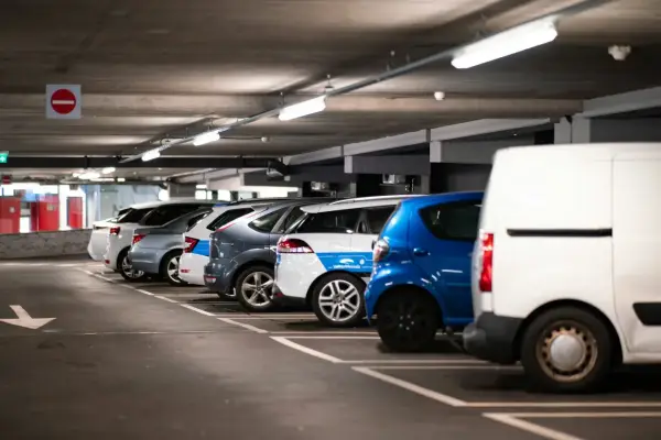 Rząd samochodów na parkingu podziemnym, gdzie czujnik parkowania do garażu ułatwia manewrowanie.